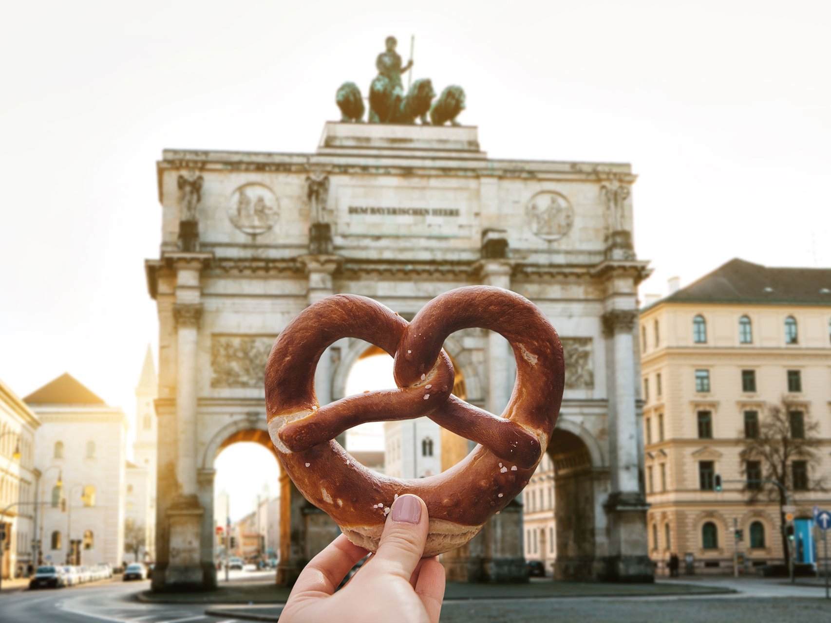 Symbolbild: Breze, dahinter das Siegestor von München